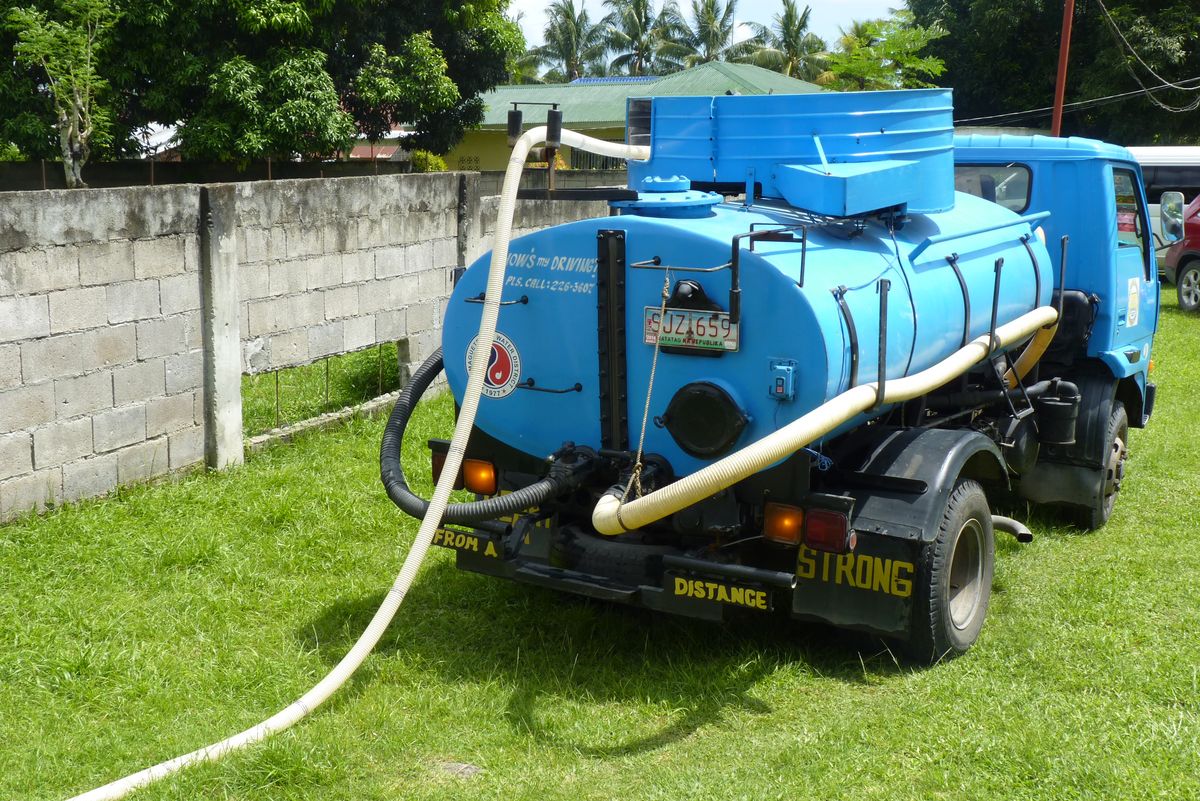 Truk vakum menyedot septic tank dengan selang panjang untuk perawatan berkala